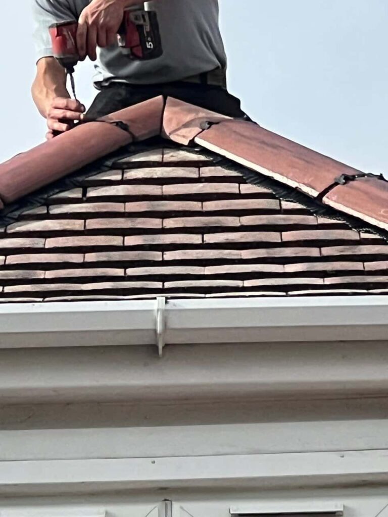 This is a photo of one of the operatives of Midhurst Roofing Repairs installing new ridge tiles